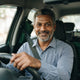 A smiling Indian male taxi driver portrait representing a satisfied customer for a financial tool service.