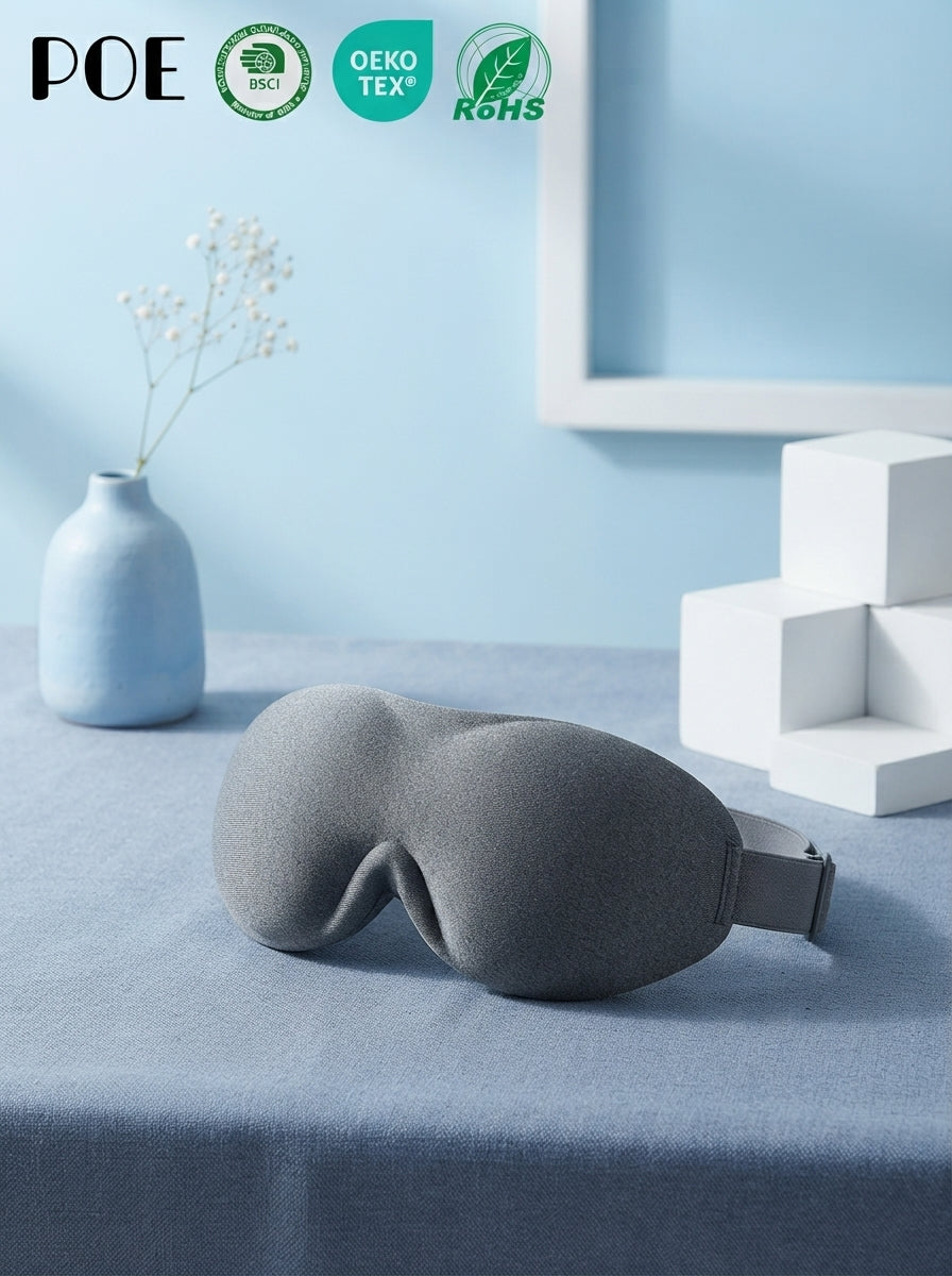 Cooling Comfort 3D Eye Mask resting on a textured slate blue fabric surface with minimalist decor in sky blue and white.